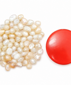 Pile of white and pinkish freshwater pearls next to a red circular lid on a white background","Loose pearls scattered beside a red round cap","Freshwater pearls spread out with a bright red lid nearby","Pearls arranged in a cluster with a red circular container lid","Close-up of pearl beads with a red cap on white background
