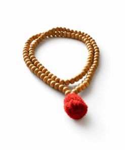 Wooden bead mala necklace with a red tassel arranged in a loop on a white background.