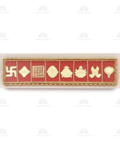 Red rectangular decorative plaque with gold embossed Hindu symbols and a beaded gold border set on a pale backing