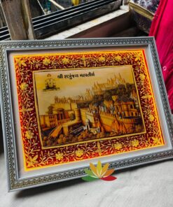 Ornate framed art print showing a golden cityscape with temples, Gujarati text at the top, set on a red border panel.