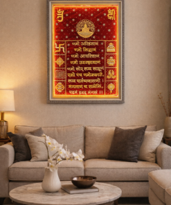 Beige living room with a framed red-and-gold devotional panel above the sofa, featuring Sanskrit text and symbols.