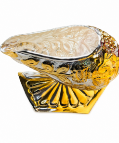 Ornate glass shell sculpture with gold and silver detailing resting on a scalloped base.