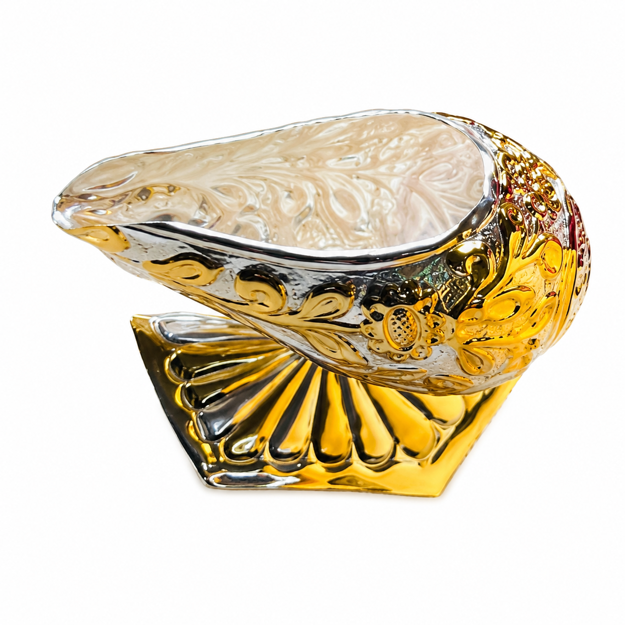 Ornate glass shell sculpture with gold and silver detailing resting on a scalloped base.