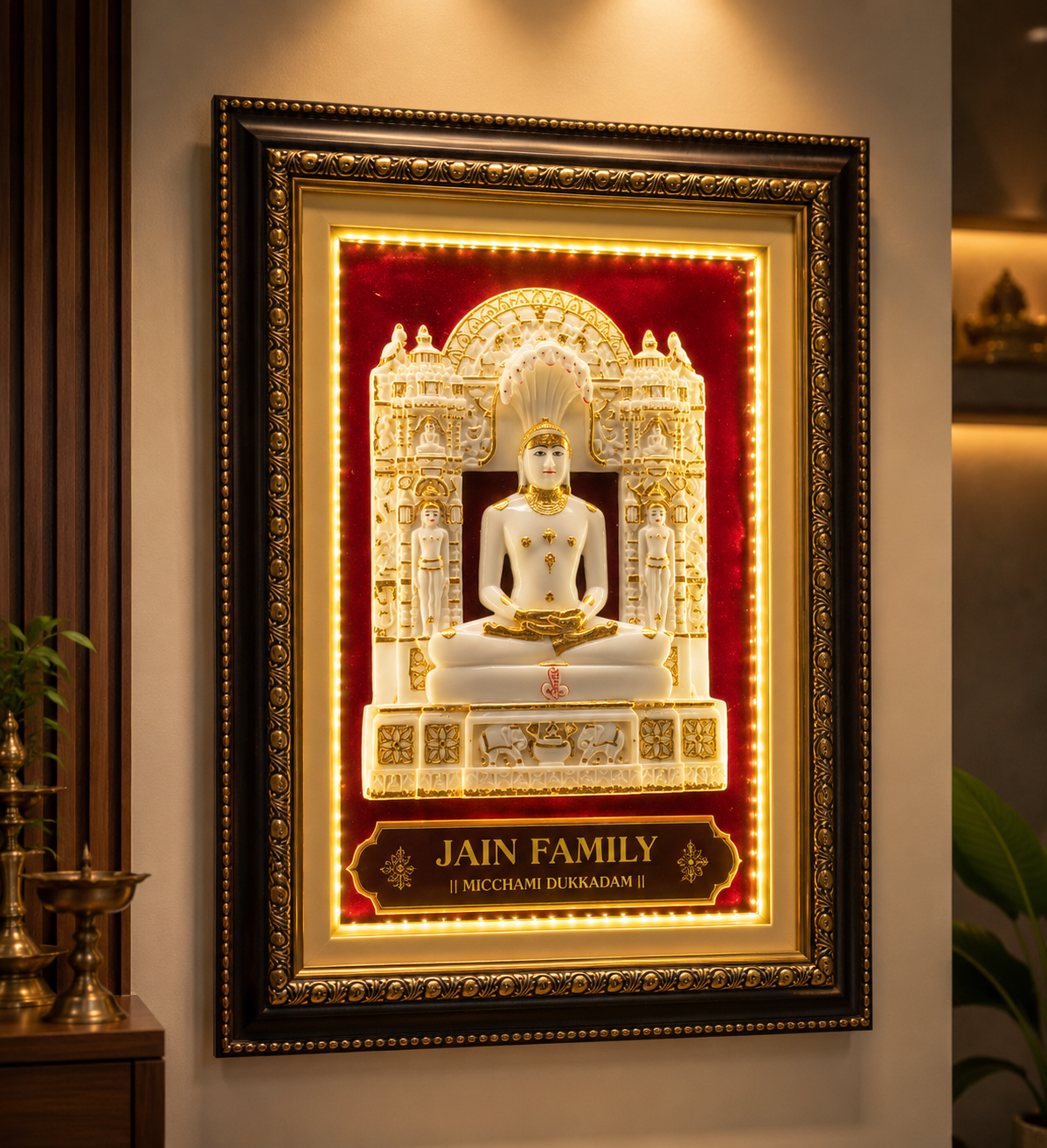 Ornate framed Jain statue on a red velvet background with gold detailing and a plaque reading 'JAIN FAMILY' beneath.