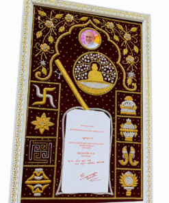 Ornate framed embroidery panel with gold motifs on maroon background, featuring a circular photo of a man, a central medallion of a seated figure, and decorative symbols and consign with a papery note in the lower center.