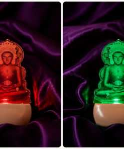 Side-by-side Buddha figurines lit in red (left) and green (right) against purple velvet fabric backdrop.