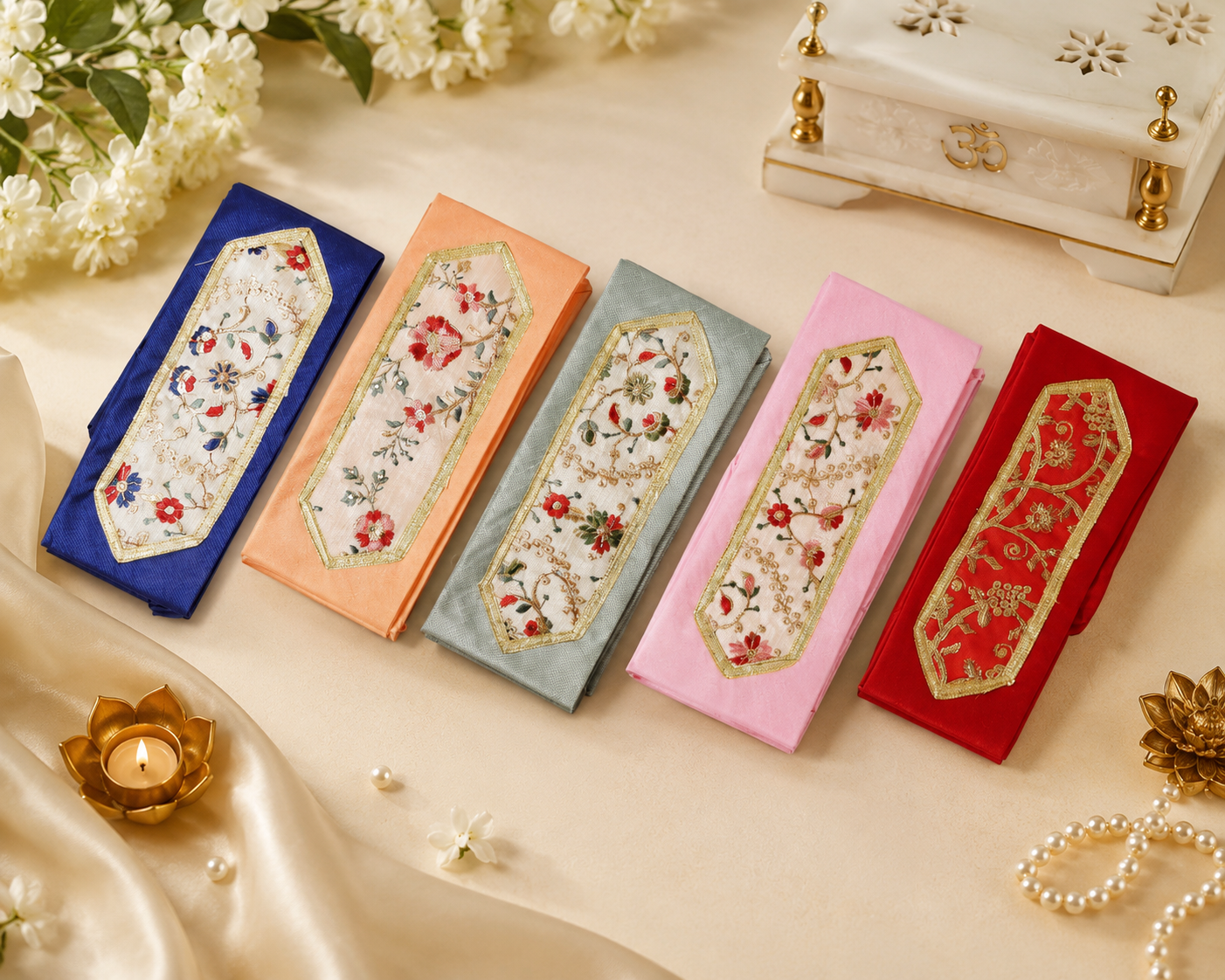 Colorful embroidered fabric pouches laid in a row on a beige surface, each with gold-bordered floral patches (blue, peach, gray, pink, red) for decorative use.