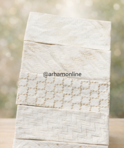 Stack of cream fabric swatches with subtle embroidered patterns arranged in a tower on a wooden surface