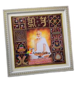 Decorative framed devotional artwork with a central portrait of a sage in white robes, surrounded by embroidered panels and a gold-trimmed frame.