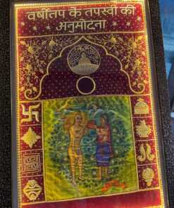 Framed embroidered textile with gold floral border and Hindi text at the top; central arch motif and a colorful scene of two figures exchanging an object in a green field, surrounded by ornate decorations.