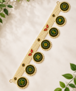 Gold pearl-edged necklace with green circular medallions featuring a gold symbol motif on a cream background.