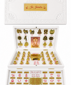 Ornate white display case opened to reveal gold Jain icons: central medallion and circular symbols, plus rows of small gold idols with red inscriptions and a central seated figure.