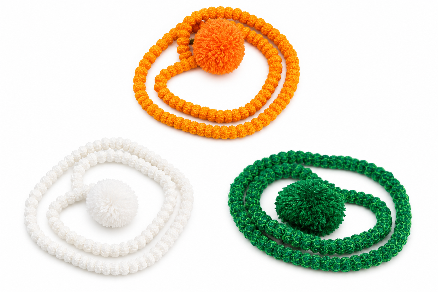 Three beaded bracelets with large pom-poms in orange, white, and green laid in circular shapes on a white background.