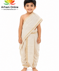 Happy young boy in cream dhoti and sash, barefoot, standing in a studio with Arham Online logo in the top-left.