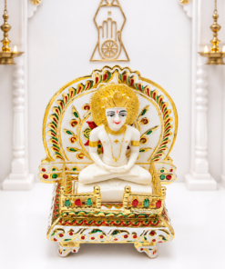 Ornate white Jain Tirthankar idol seated cross-legged on a gold-trimmed, jewel-encrusted throne.